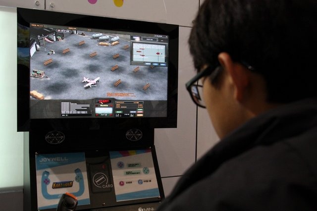 今年も韓国釜山市で開催中の韓国最大級のゲームショウG-STAR。オンラインゲームブース、スマフォ・タブレットゲームブースが多く並んでいる中、道行く人が足を止めているブースがありました。