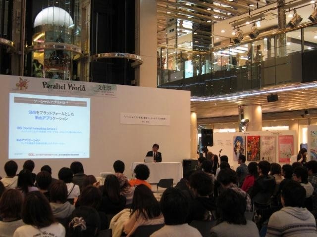 日本デザイナー学院九州校と、姉妹校の日本ビジネススクール九州校による文化祭で10月21日、ソル・エンタテインメントCEOの神江豊氏は「ソーシャルアプリ市場と最新ソーシャルアプリの事例」と題して講演を行いました。