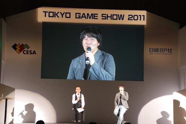 今年は3部構成となった東京ゲームショウ（TGS）の基調講演。そのトリをつとめたのが、SNSサービス「GREE（グリー）」を展開する、同社の田中良和社長です。基調講演は「ソーシャルゲームが起こすパラダイムシフト」と題して、日経BP者の品田英雄氏を聞き手に、対談形式