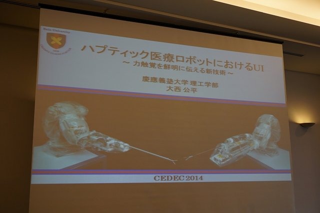 慶應義塾大学の大西公平氏の講演「医療ロボットに学ぶバーチャルリアリティのUI」では、先端医療装置「ダ・ヴィンチ」に用いられている「力触覚」を鮮明に伝える技術の説明と、遠隔操作UI（実世界ハプティクス）の公開実験が行われました。