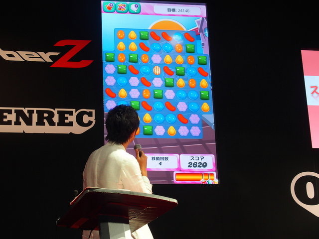 東京ゲームショウでCyberZはブースを出展し、スマホゲームプレイ動画共有サービス「OPENREC」のアピールを行いました。特設ステージではタレントの鈴木奈々さんを迎え、最近ハマっているという『キャンディクラッシュサーガ』のプレイ大会を開催。スタッフのサポートも