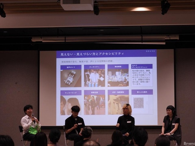 4人の登壇者が並んで座るパネルディスカッションの様子。背後のスクリーンには『見えない・見えづらい方とアクセシビリティ』と題されたスライドが投影され、音声ガイドなどの事例が写真付きで紹介されている